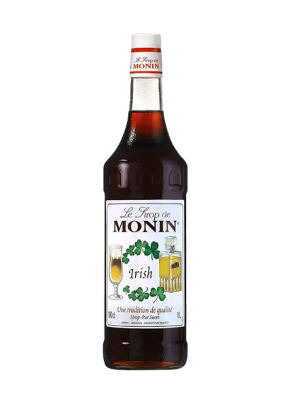 A tall, clear glass bottle of Monin 'Irish' Syrup, showcasing a rich, dark brown liquid. The label is cream-colored with elegant black and red text. At the top, 'Le Sirop de MONIN' is prominently displayed in cursive font. Below it, the flavor 'Irish' is printed in bold, with a visual illustration of coffee beans, a glass of Irish coffee, and a splash of cream to evoke its classic creamy, whiskey-inspired profile. The bottle is topped with a red and white screw cap, giving it a professional and café-style a